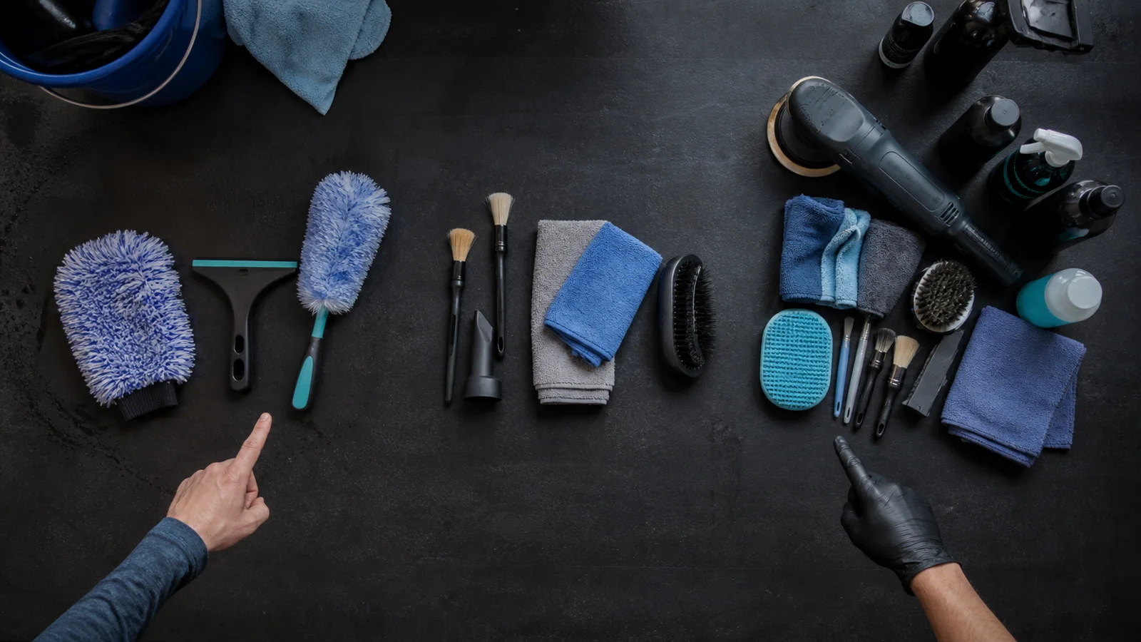 Overhead comparison of basic wash, interior cleaning, and full-detail tools arranged on a dark worktable